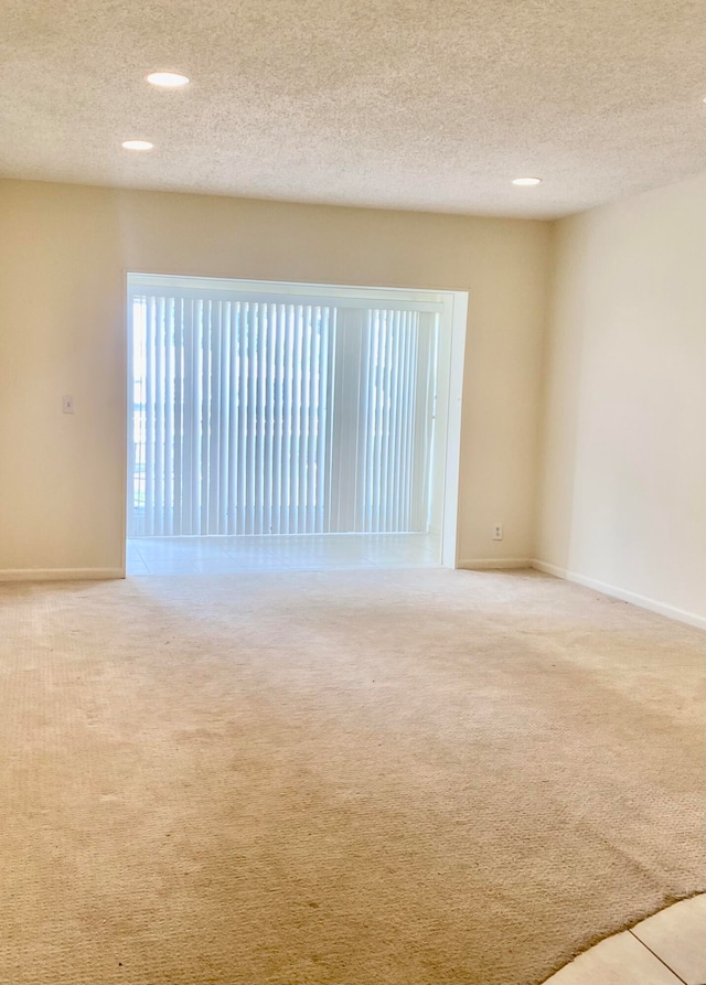 carpeted spare room with a textured ceiling