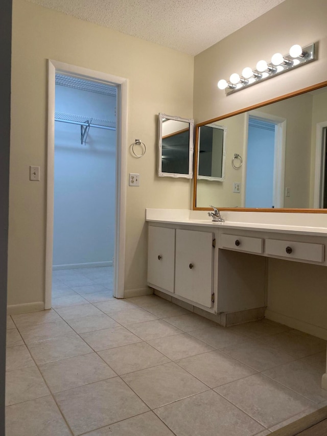 bathroom with vanity, a textured ceiling, and tile patterned floors