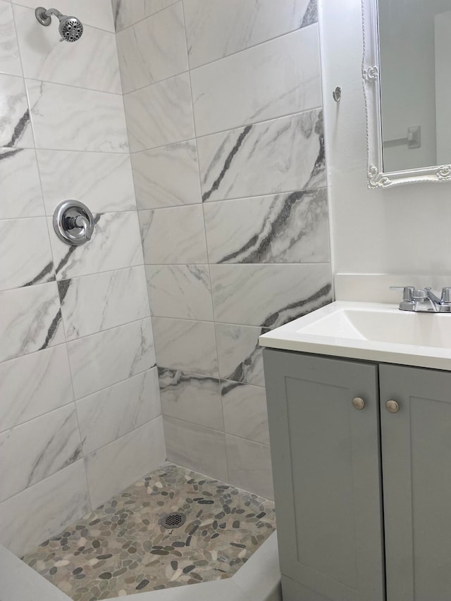 bathroom featuring a tile shower and vanity