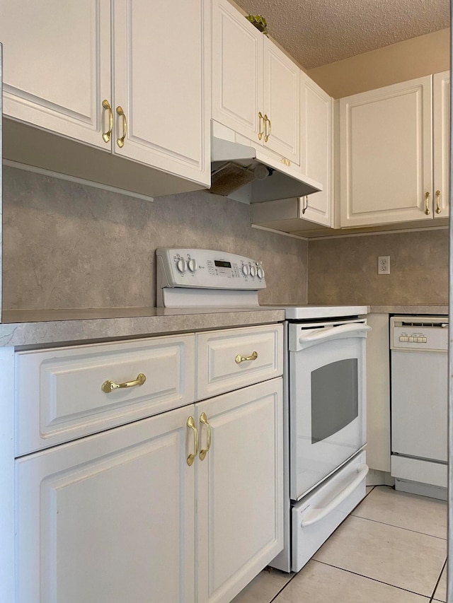 kitchen with white cabinetry, white appliances, light tile patterned floors, and a textured ceiling