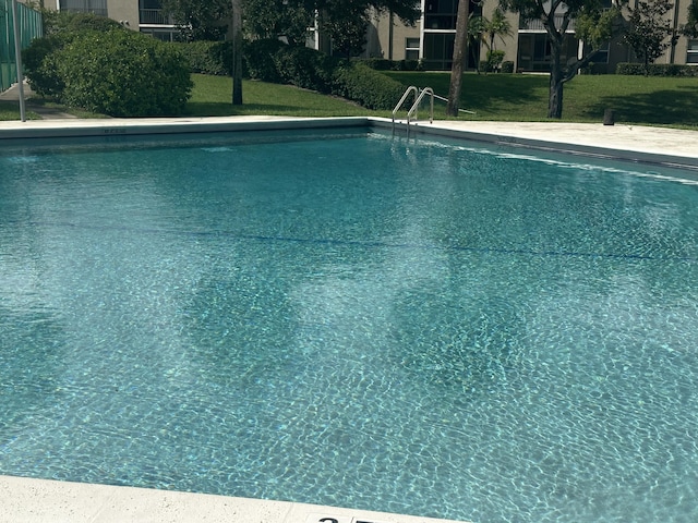 view of swimming pool with a lawn