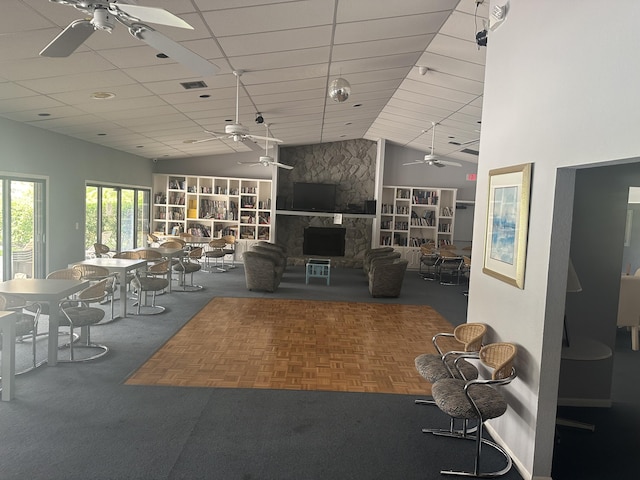 unfurnished living room featuring vaulted ceiling, carpet flooring, and a stone fireplace