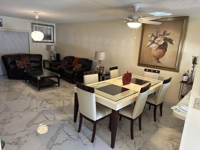 dining space with ceiling fan and a textured ceiling