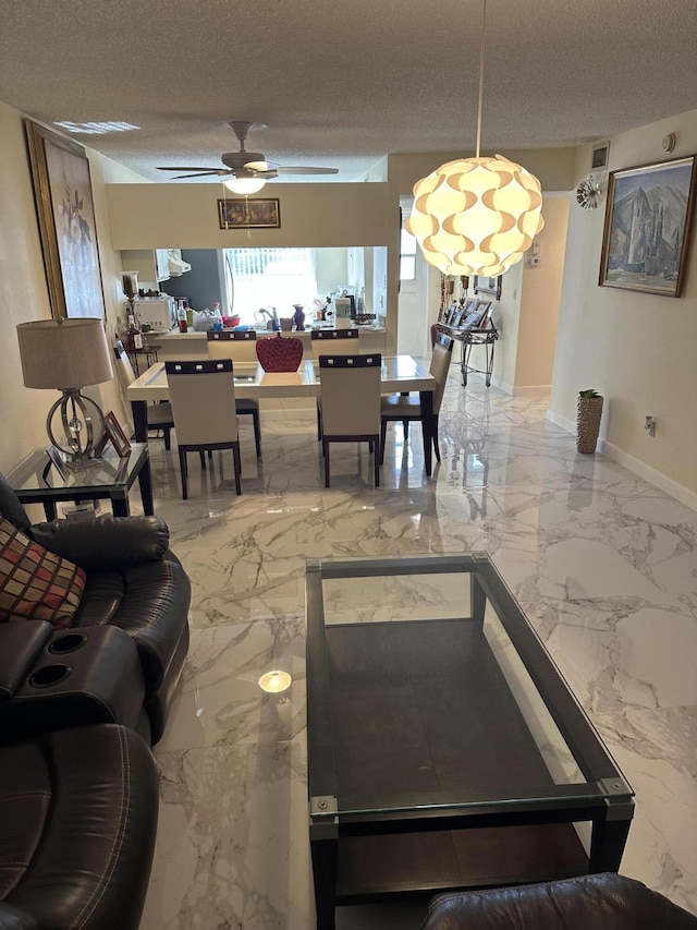 living room with ceiling fan and a textured ceiling