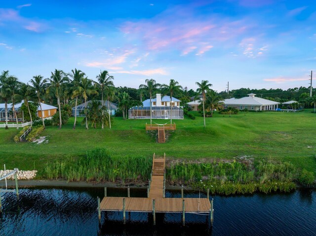 view of dock featuring a water view and a yard