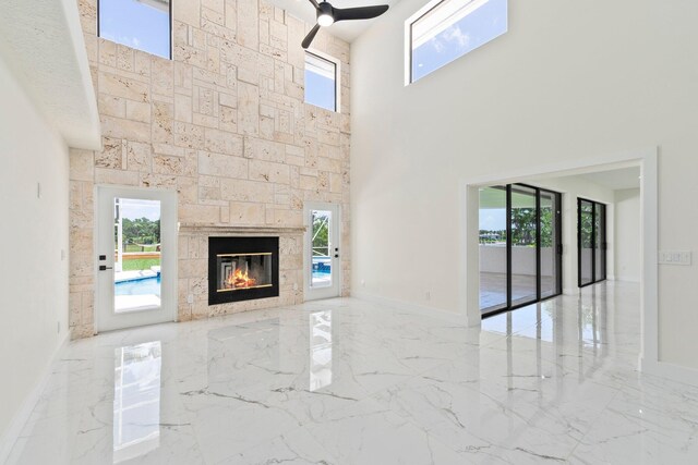 unfurnished living room featuring plenty of natural light and ceiling fan