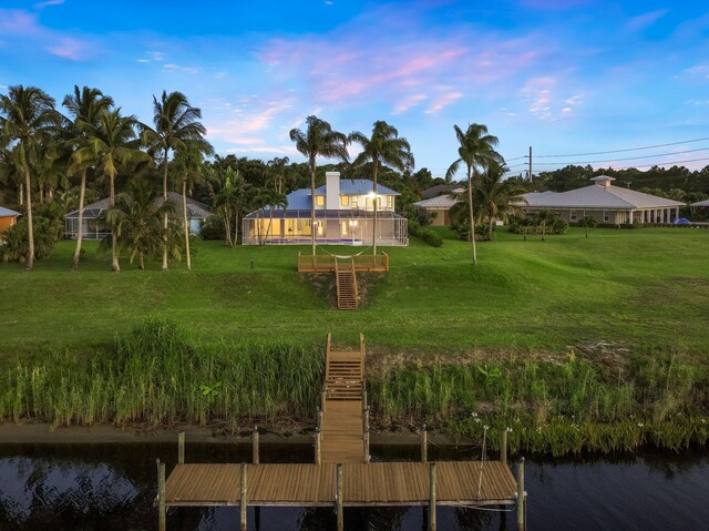 back of property featuring a water view, a yard, and a trampoline