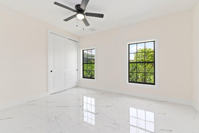 spare room with a healthy amount of sunlight and ceiling fan