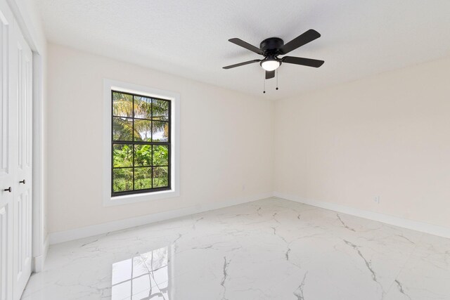 unfurnished room featuring a textured ceiling and ceiling fan