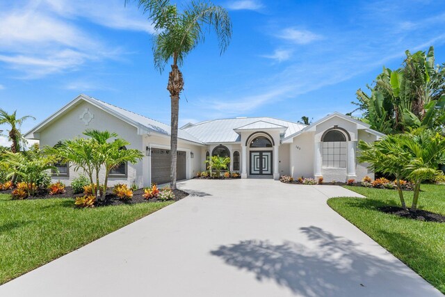 view of front of house with a garage and a front lawn