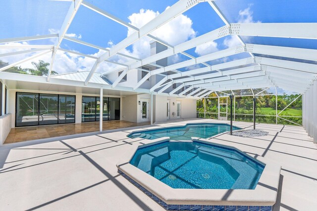 view of pool with a lanai, a patio area, and an in ground hot tub