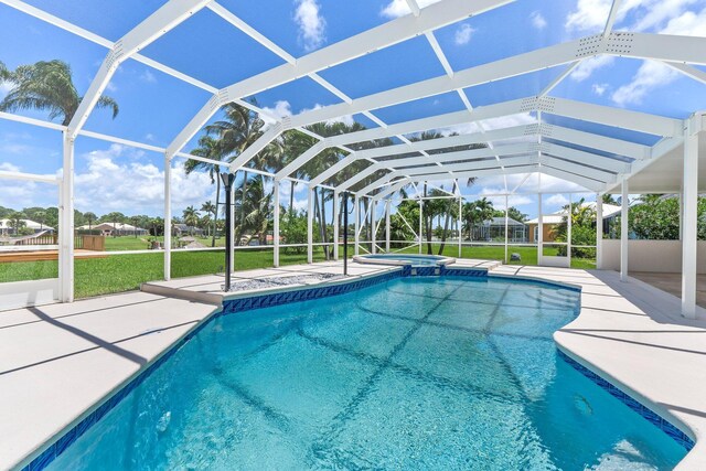 view of swimming pool with a yard, a patio, and glass enclosure