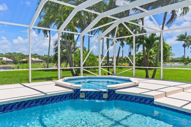 view of swimming pool with a yard, pool water feature, a patio, and glass enclosure