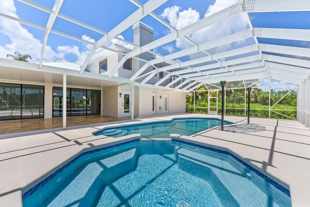 view of swimming pool featuring glass enclosure and a patio area