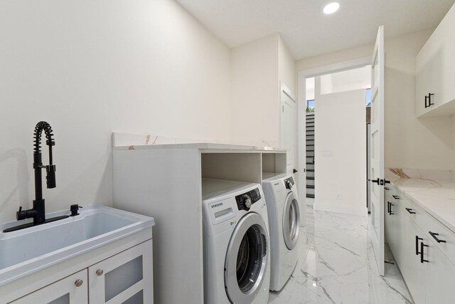 laundry area with washer and dryer, cabinets, and sink