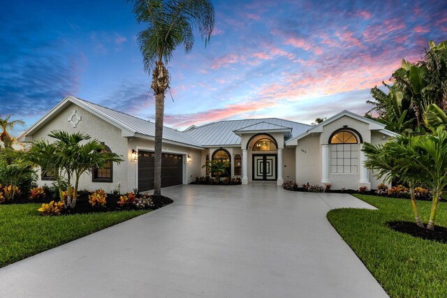 ranch-style home featuring a garage and a yard