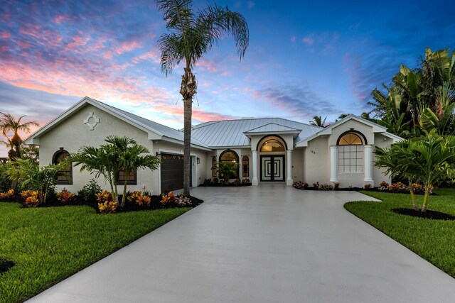 ranch-style home with a garage and a yard