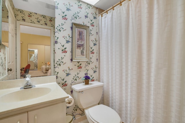 bathroom featuring a shower with shower curtain, toilet, and vanity