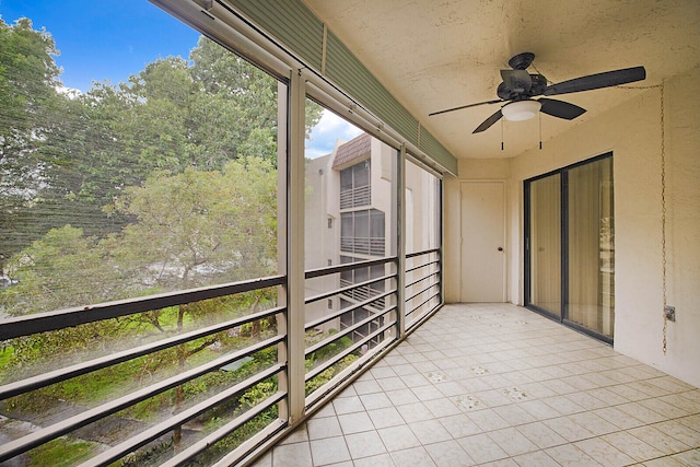 unfurnished sunroom featuring ceiling fan