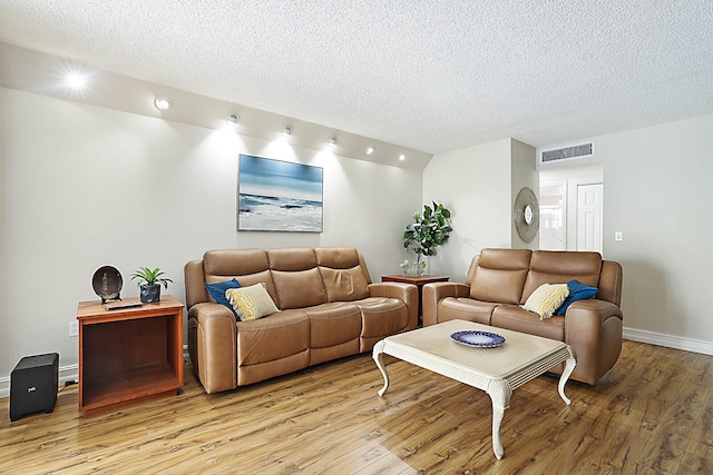 living room featuring a textured ceiling and hardwood / wood-style floors