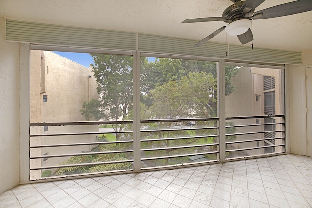 unfurnished sunroom featuring ceiling fan