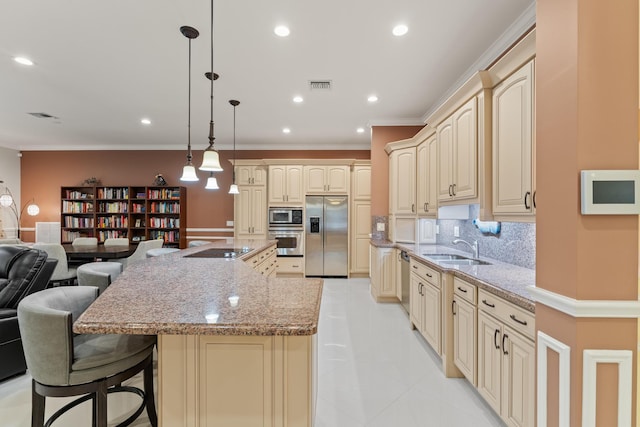 kitchen featuring light stone counters, sink, a kitchen bar, decorative backsplash, and appliances with stainless steel finishes