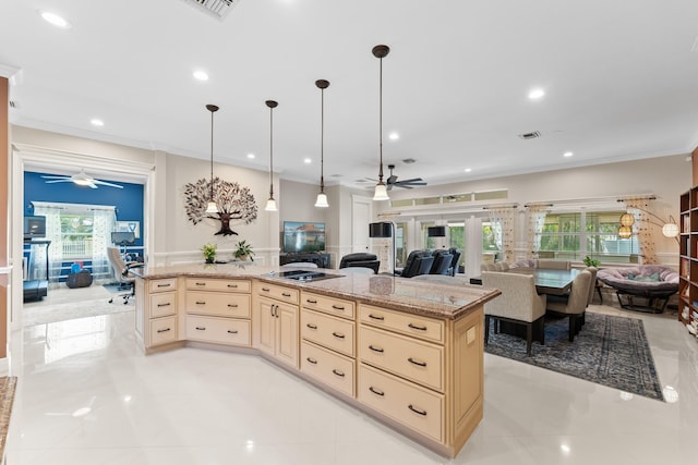 kitchen featuring hanging light fixtures, ornamental molding, light stone counters, and a wealth of natural light