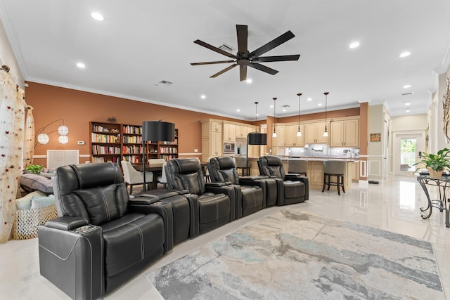 home theater room with ceiling fan, light tile patterned flooring, and ornamental molding