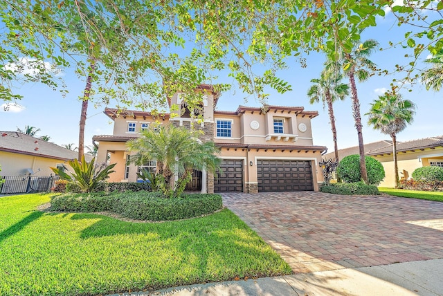 mediterranean / spanish home featuring a front lawn and a garage