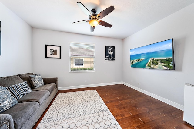 living room with dark wood-type flooring and ceiling fan