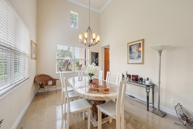 dining area featuring light tile patterned flooring, a towering ceiling, crown molding, and a notable chandelier