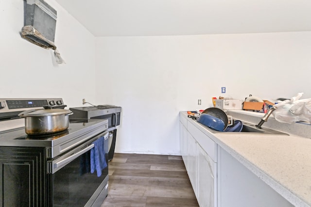 kitchen featuring stainless steel electric range oven, white cabinets, and dark hardwood / wood-style floors