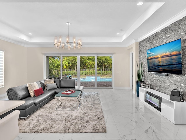 living room featuring a chandelier, a tray ceiling, and ornamental molding