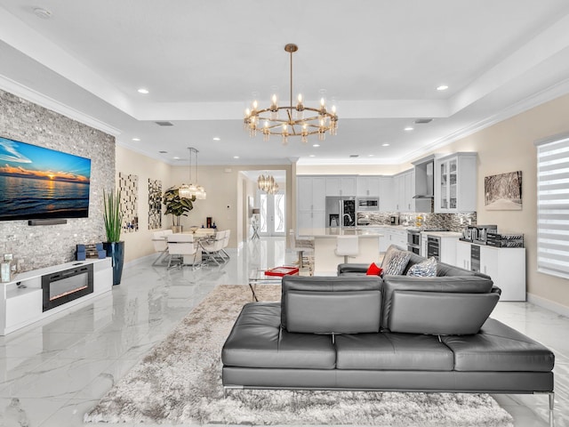 living room with a notable chandelier, plenty of natural light, a stone fireplace, and crown molding