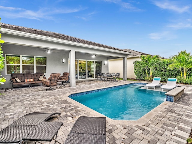 view of swimming pool with outdoor lounge area, ceiling fan, and a patio area