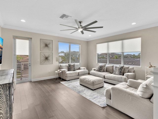 living room featuring dark hardwood / wood-style flooring, ceiling fan, and crown molding