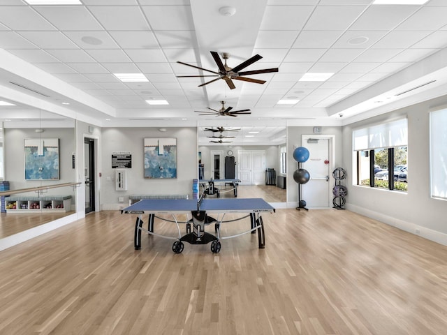 workout area with ceiling fan, a drop ceiling, and light hardwood / wood-style flooring