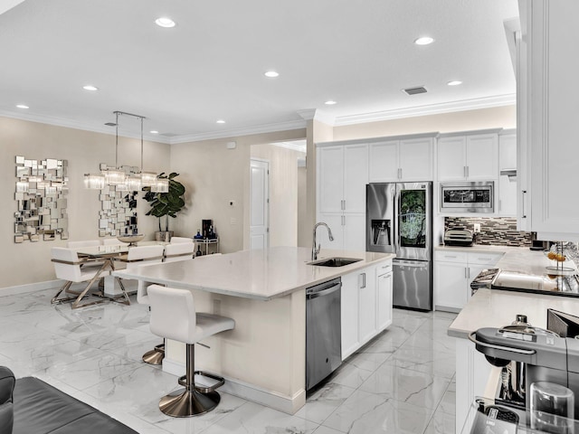 kitchen with white cabinetry, sink, hanging light fixtures, an island with sink, and appliances with stainless steel finishes