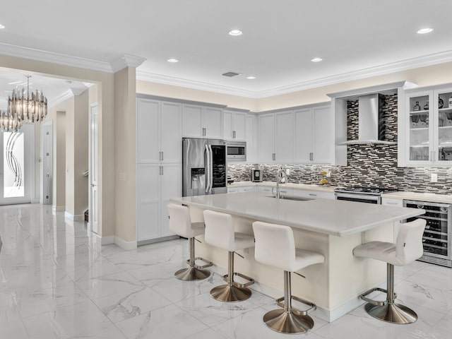 kitchen featuring sink, wall chimney range hood, wine cooler, a center island with sink, and appliances with stainless steel finishes