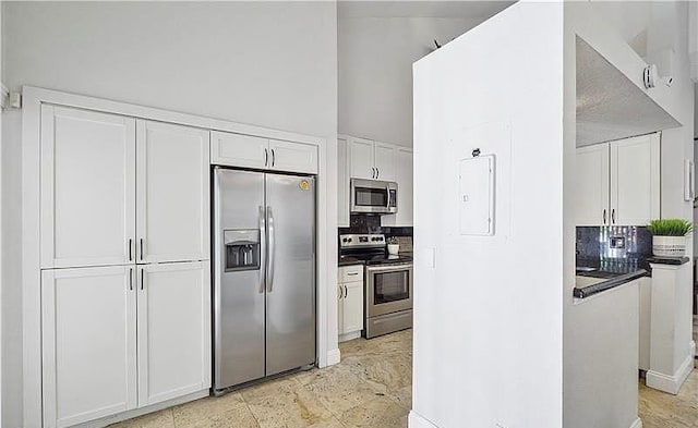 kitchen with appliances with stainless steel finishes, electric panel, backsplash, and white cabinetry