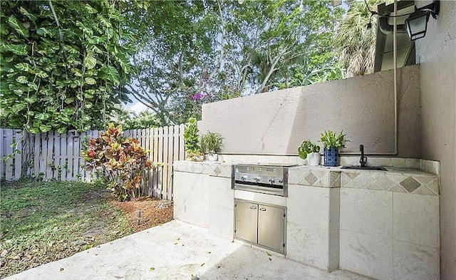 view of patio featuring an outdoor kitchen and sink