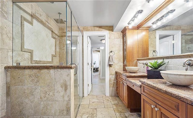 bathroom with vanity, an enclosed shower, and tile walls