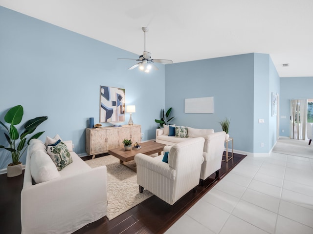 tiled living room featuring ceiling fan and vaulted ceiling