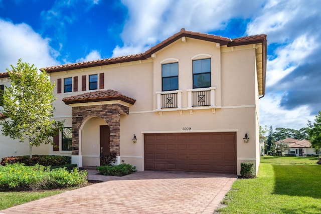 mediterranean / spanish home featuring a front yard and a garage