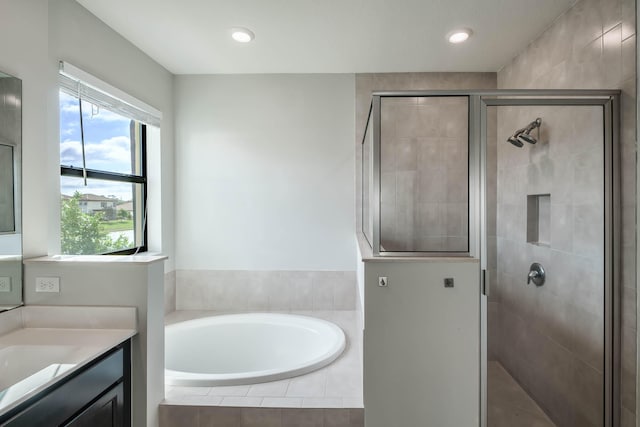 bathroom featuring vanity, a healthy amount of sunlight, and separate shower and tub