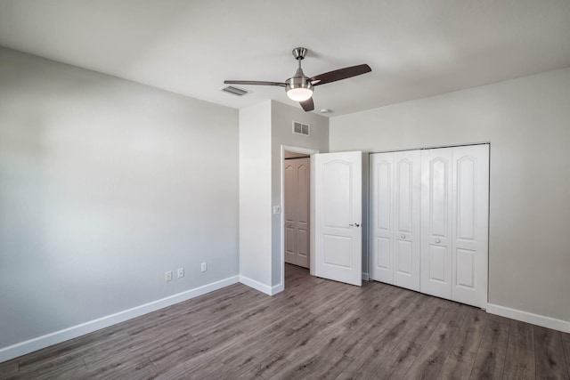 unfurnished bedroom with dark wood-type flooring, ceiling fan, and a closet