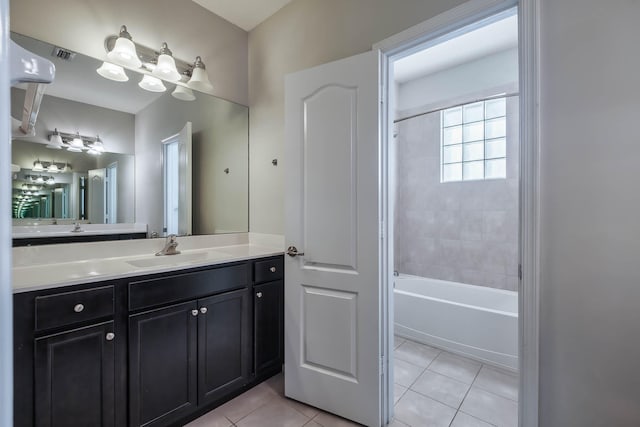 bathroom featuring tiled shower / bath combo, vanity, and tile patterned flooring