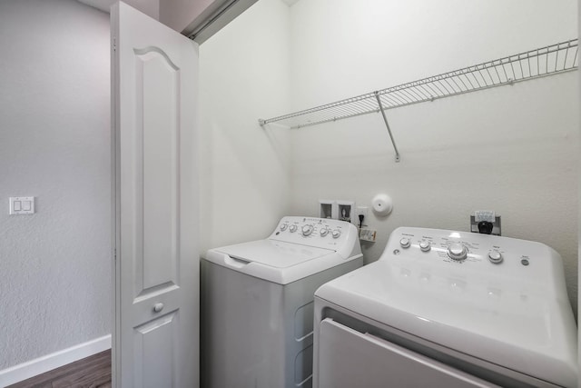 washroom with dark wood-type flooring and independent washer and dryer