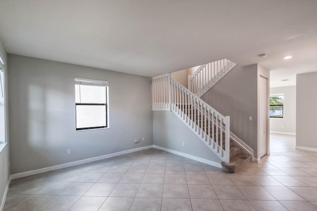 spare room with light tile patterned floors and a wealth of natural light