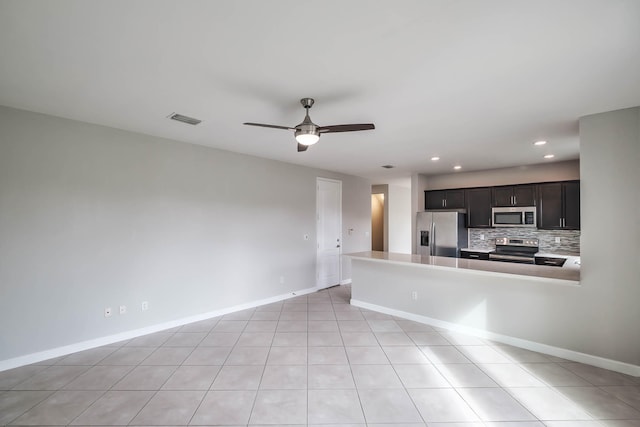 kitchen with stainless steel appliances, light tile patterned floors, backsplash, and ceiling fan